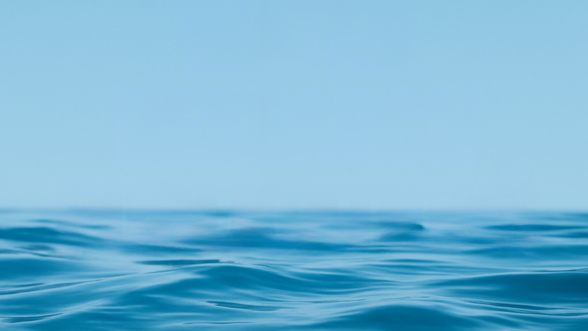 Waves of water beneath a blue sky
