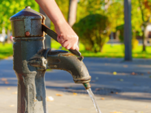 Hand pumping water from a well