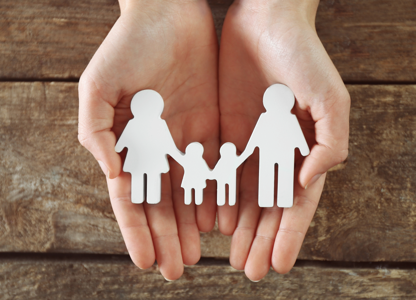 Hands holding a model of a family